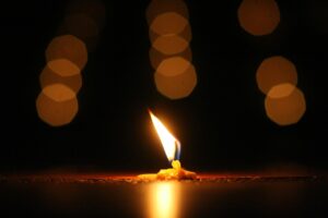 Black candle glowing with soft light during meditation, symbolizing tranquility, peace, and the transformative power of meditation in creating inner calm.