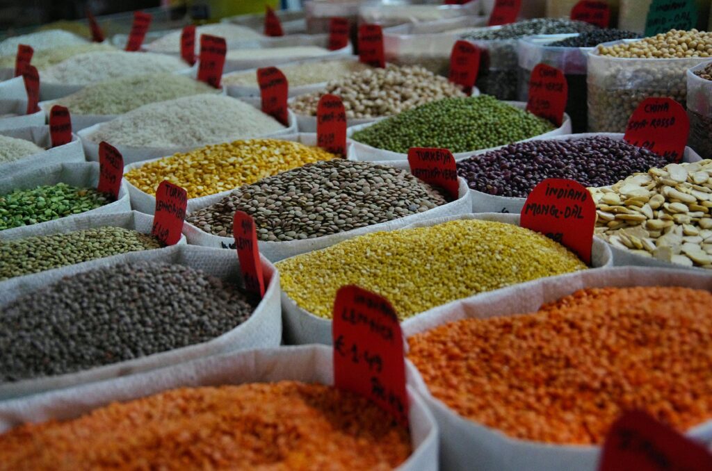 Colorful bags of grains and spices on display in a bustling market, showcasing nutrient-rich choices that help combat food and fatigue.