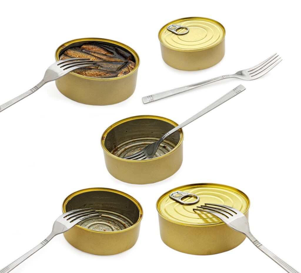 A close-up photo of a freshly opened can of tuna on a table, illustrating the metal container and food contents to highlight the importance of canned food safety.