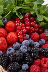 A close-up of various ripe, fresh fruit and berries, showcasing their vibrant color and texture. A colorful assortment of different types of berries (including strawberries, blueberries, and raspberries). These ripe, fresh fruits are packed with antioxidants, making them a delicious way to enjoy the comprehensive health benefits of berries for cardiovascular and cognitive function.