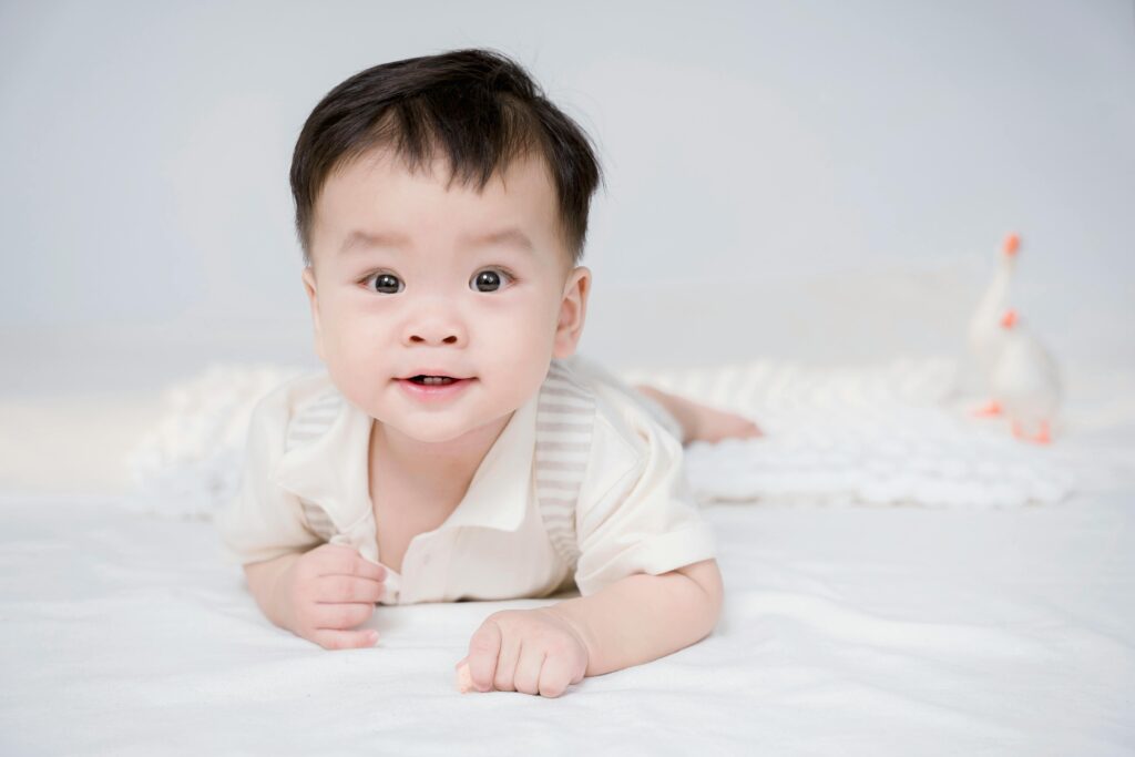 A comfortable newborn baby in a safe, loose-fitting white outfit, illustrating the key principles of how to dress a newborn.