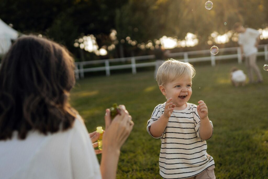 Weakened Immune System in Children: Top Causes & Prevention 1 A young child playing outdoors, delighted by bubbles, exemplifies how fun activity in fresh air helps prevent a weakened immune system in children.