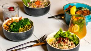 A vibrant assortment of healthy bowls and citrus drinks featuring fresh vegetables and fruits, highlighting nutrient-rich options for an anorexia diet plan.
