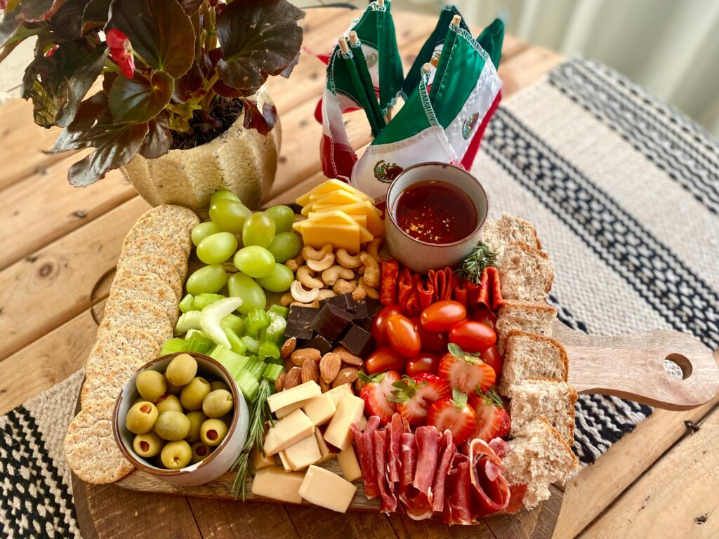 Charcuterie board with fruits and cheese promoting body heat regulation and healthy digestion. Wholesome foods like fruits and cheese help maintain body heat regulation, supporting smooth and efficient digestion.