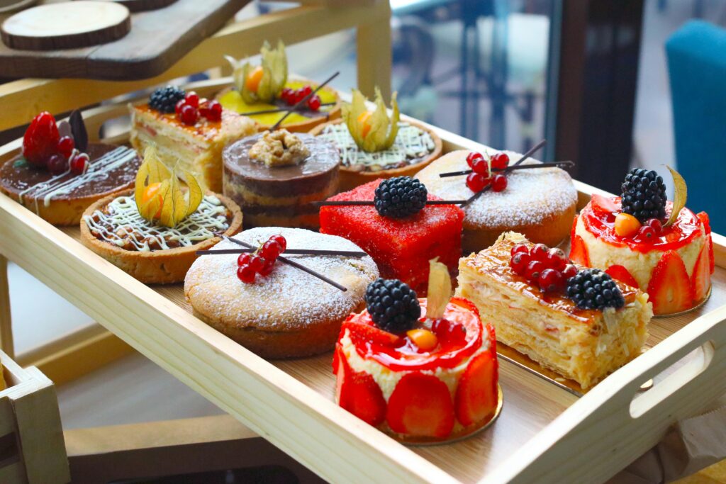 Tempting cakes and pastries highlight how refined carbohydrates and excess glucose contribute to diabetes and energy crashes. An assortment of fancy pastries and cakes, common sources of hidden glucose dangers in modern diets.